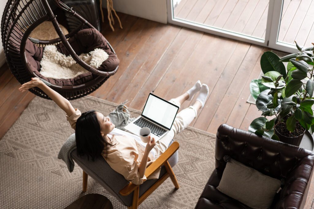 carefree happy asian girl finish working looking satisfied sitting home with laptop computer